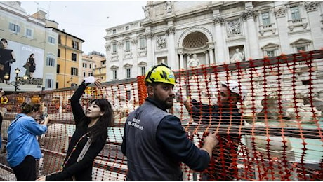 Fontana di Trevi ingabbiata, tra lo stupore dei turisti e i lanci di monetine a distanza